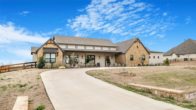 view of front of house with concrete driveway, board and batten siding, and fence