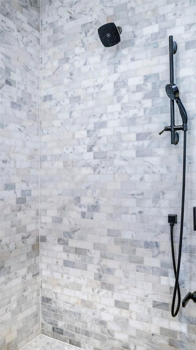 interior details featuring tiled shower