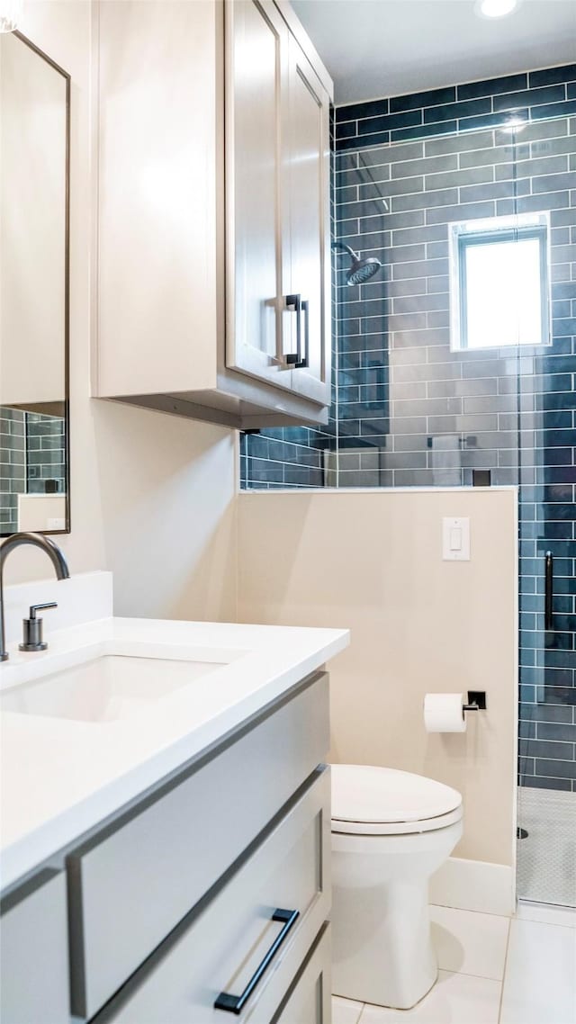 full bathroom with a stall shower, tile patterned flooring, vanity, and toilet