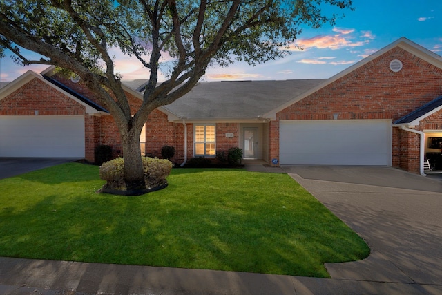 ranch-style home featuring driveway, brick siding, a lawn, and an attached garage