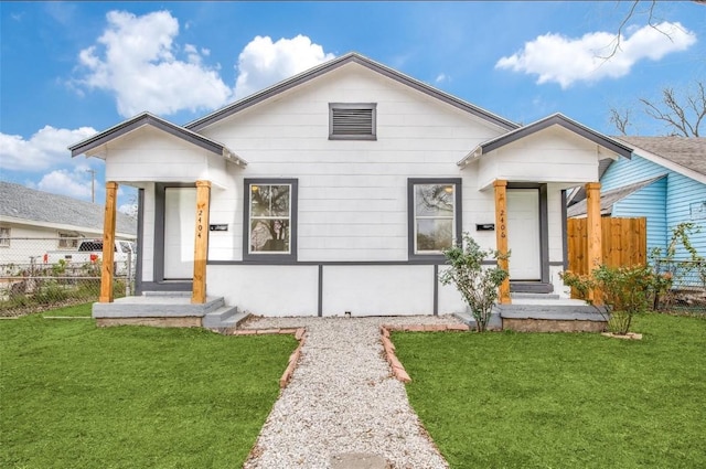 view of front of home with a front yard and fence