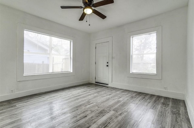 empty room featuring ceiling fan, wood finished floors, and baseboards