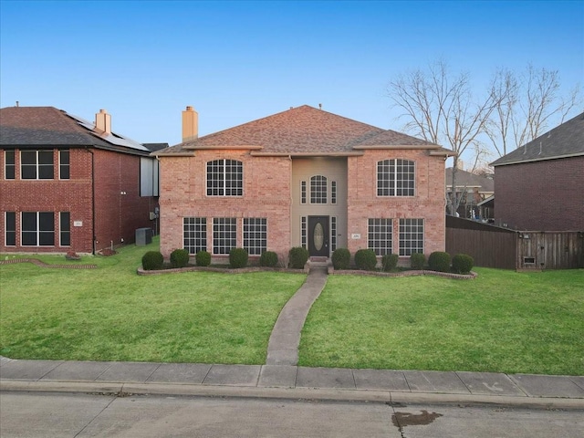 view of front facade featuring roof with shingles, brick siding, central AC unit, fence, and a front lawn