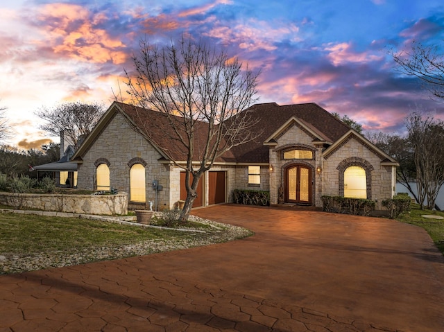 view of front of home with a garage, driveway, and french doors