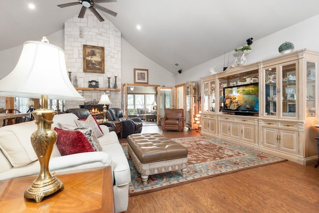 living room with high vaulted ceiling, a ceiling fan, a fireplace, and wood finished floors