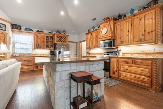 kitchen with appliances with stainless steel finishes, visible vents, dark wood finished floors, and glass insert cabinets