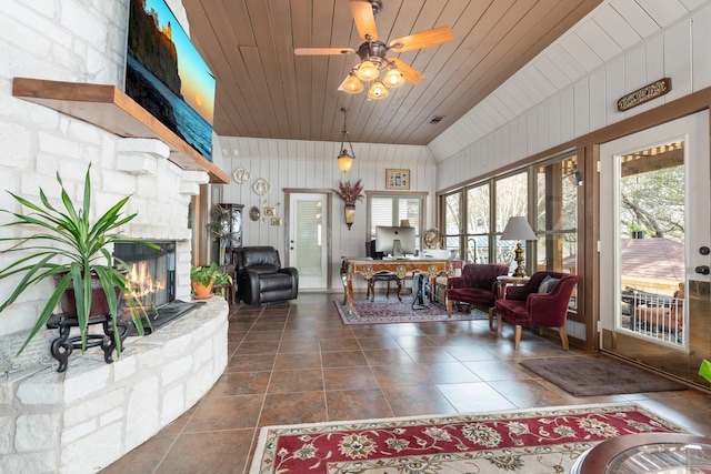 sunroom with wooden ceiling, visible vents, and a stone fireplace