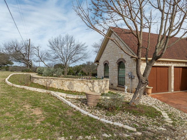 view of front facade featuring a garage, stone siding, and roof with shingles