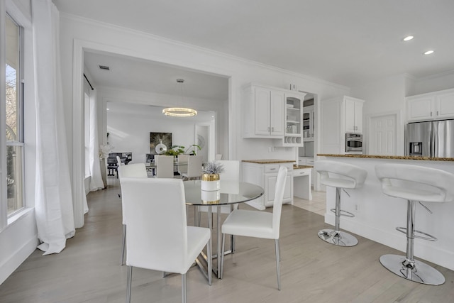 dining space featuring recessed lighting, light wood-style flooring, and crown molding