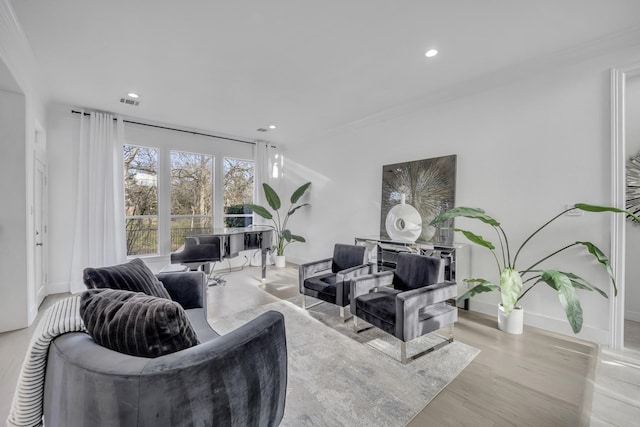 living area with recessed lighting, wood finished floors, visible vents, baseboards, and crown molding