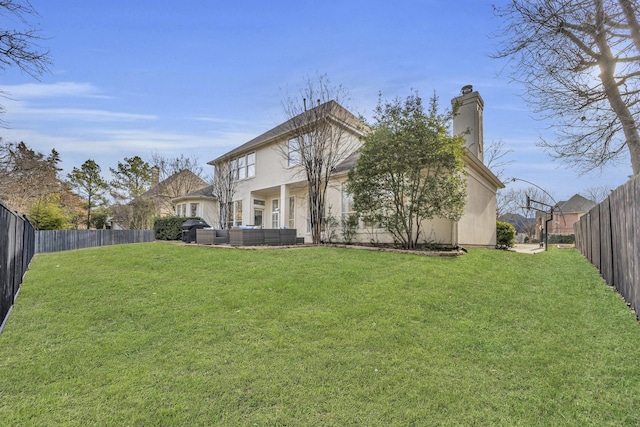 rear view of property with a fenced backyard, a yard, and a chimney