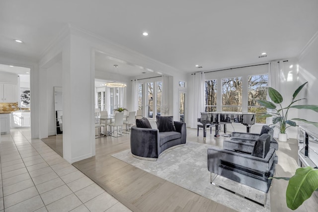 living room with plenty of natural light, ornamental molding, light wood-style flooring, and recessed lighting