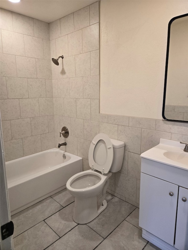 bathroom featuring tile walls, bathtub / shower combination, vanity, and toilet