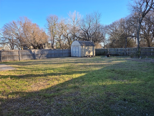 view of yard with a shed, a fenced backyard, and an outdoor structure