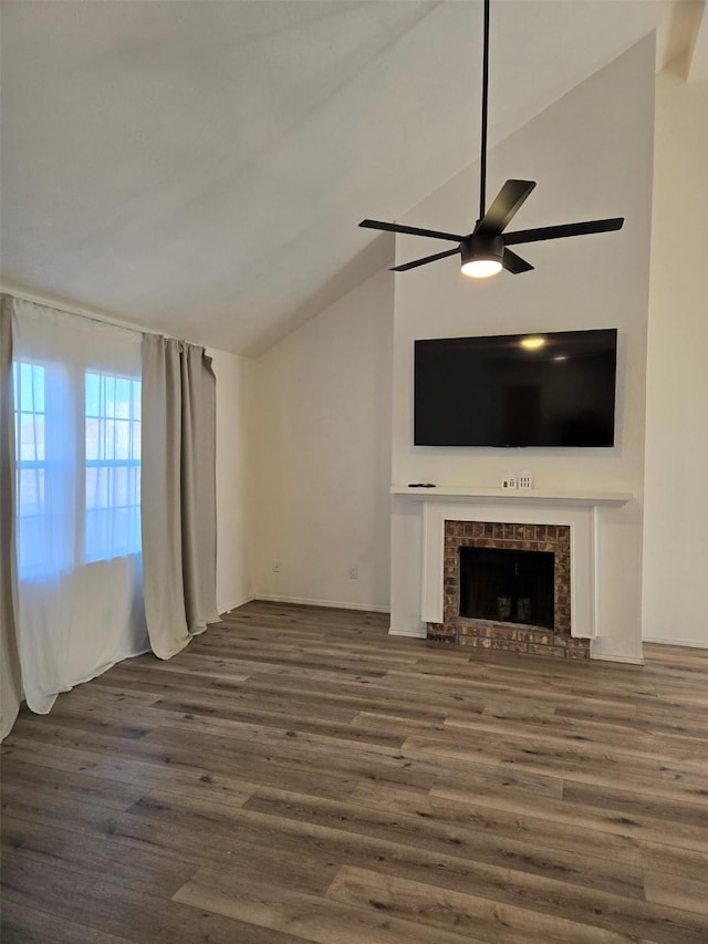 unfurnished living room with ceiling fan, lofted ceiling, a fireplace, and wood finished floors