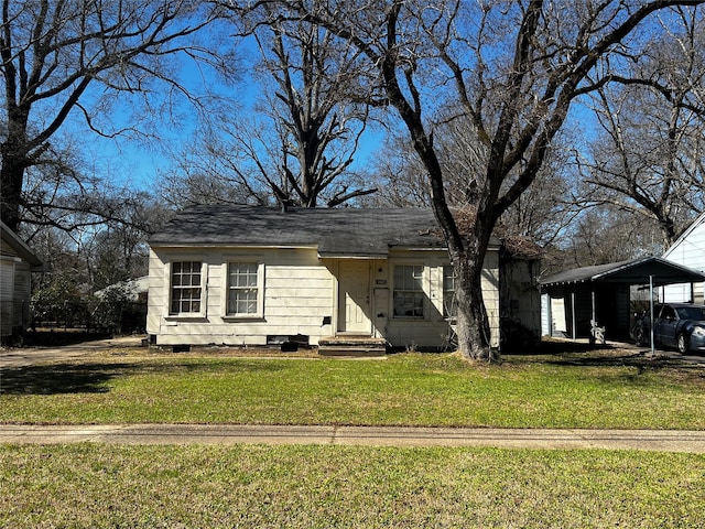 view of front facade featuring roof with shingles, a front yard, and a detached carport