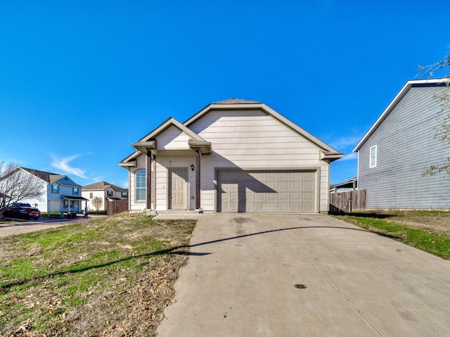 ranch-style house featuring concrete driveway, an attached garage, and fence