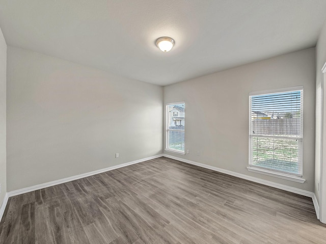 unfurnished room with baseboards and wood finished floors