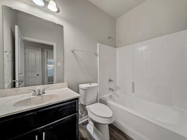 full bathroom featuring a textured wall, toilet, wood finished floors, vanity, and shower / bathing tub combination