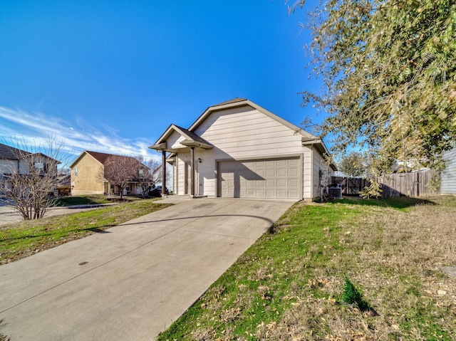 view of front of property featuring an attached garage, driveway, fence, and a front yard