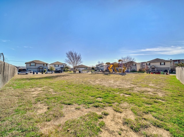 view of yard with a playground, fence, and a residential view