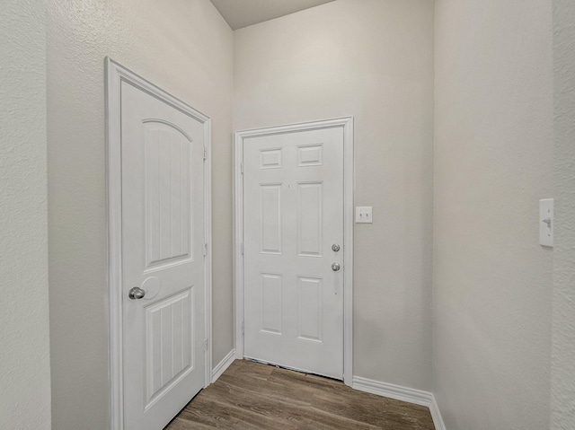 doorway to outside featuring baseboards and wood finished floors