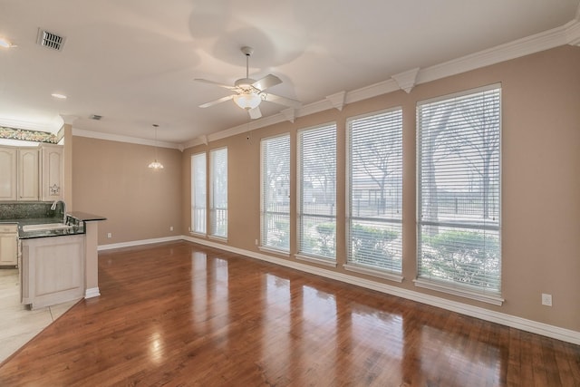 128 Oakview Dr, Hudson Oaks, TX 76087 - unfurnished living room with plenty of natural light, baseboards, a ceiling fan, a sink, and crown molding