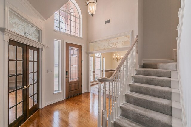 128 Oakview Dr, Hudson Oaks, TX 76087 - entrance foyer featuring french doors, stairway, wood finished floors, a chandelier, and a high ceiling