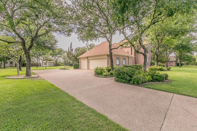 128 Oakview Dr, Hudson Oaks, TX 76087 - view of side of home with brick siding, driveway, a garage, and a yard