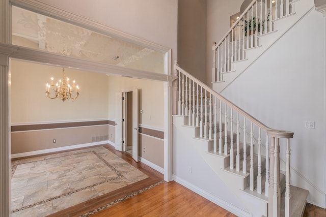 128 Oakview Dr, Hudson Oaks, TX 76087 - stairs with a chandelier, inlaid floor details, baseboards, and stone tile flooring