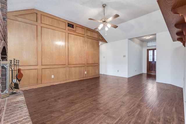 7425 Dana Ln, North Richland Hills, TX 76182 - unfurnished living room with a fireplace, lofted ceiling, visible vents, dark wood-type flooring, and ceiling fan