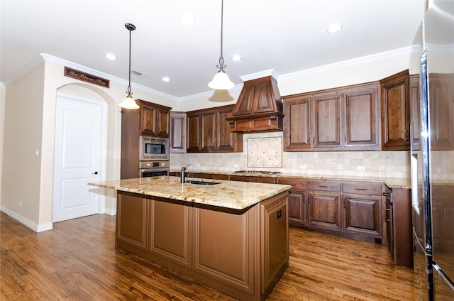 kitchen featuring premium range hood, dark wood-type flooring, a sink, visible vents, and appliances with stainless steel finishes