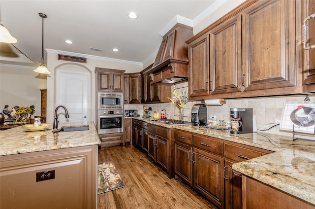 kitchen featuring light stone counters, a sink, light wood-style floors, ornamental molding, and appliances with stainless steel finishes