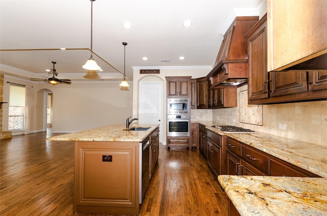 kitchen with stainless steel appliances, crown molding, a sink, and light stone counters