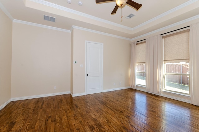 unfurnished room with baseboards, wood finished floors, visible vents, and crown molding