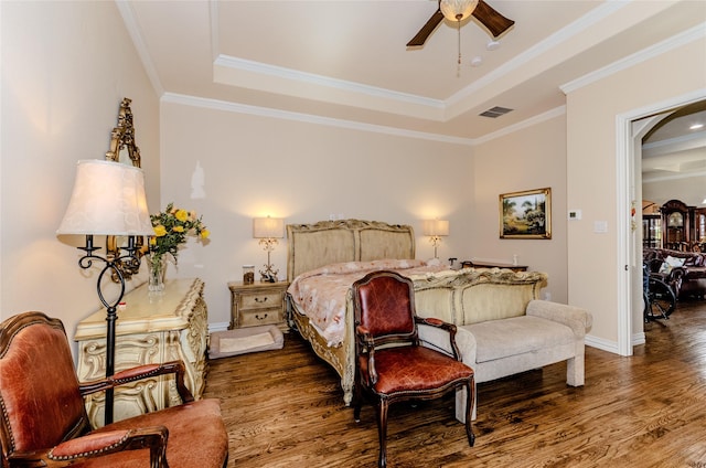 bedroom with visible vents, a raised ceiling, and wood finished floors