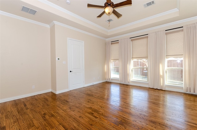 empty room with crown molding, visible vents, ceiling fan, and wood finished floors