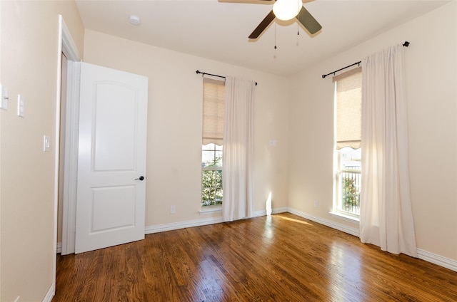 spare room with a healthy amount of sunlight, baseboards, and wood finished floors