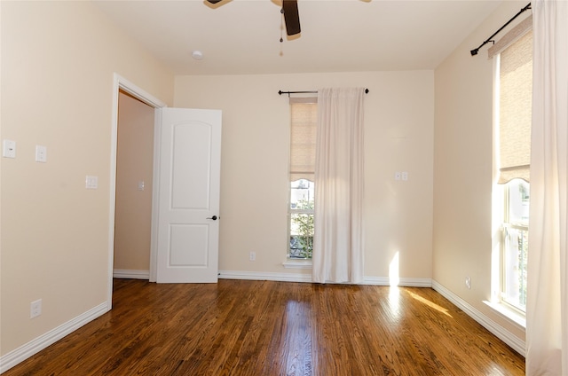 empty room featuring a ceiling fan, baseboards, and wood finished floors