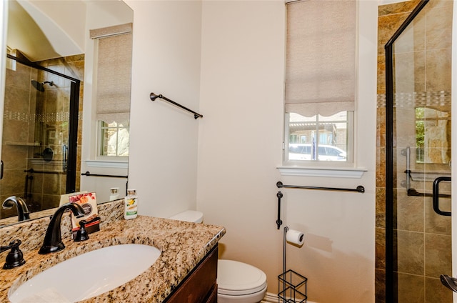 bathroom with a stall shower, vanity, and toilet