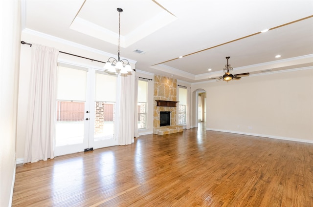 unfurnished living room with ornamental molding, a tray ceiling, and light wood finished floors