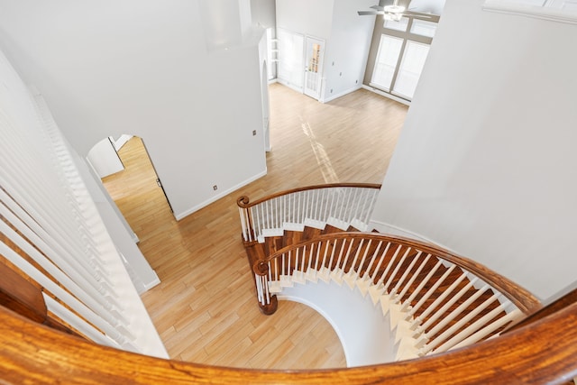 stairs featuring ceiling fan, wood finished floors, and baseboards