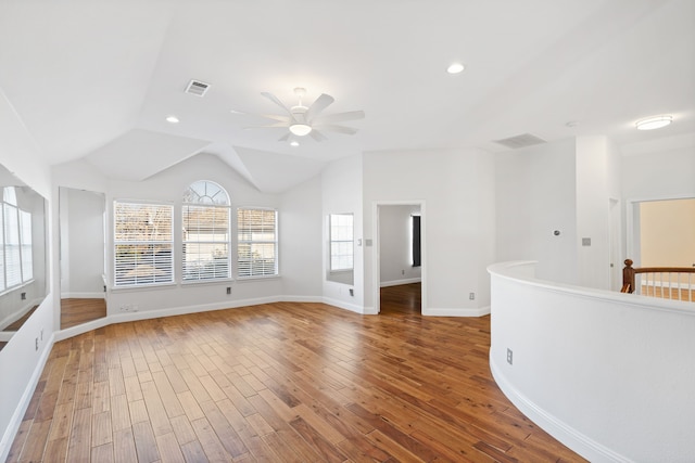 unfurnished room featuring lofted ceiling, visible vents, baseboards, and wood finished floors