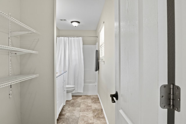 bathroom featuring visible vents, baseboards, toilet, shower / bath combo with shower curtain, and vanity