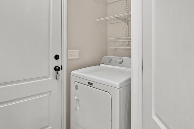 clothes washing area featuring washer / clothes dryer and laundry area