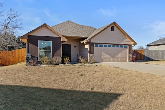 ranch-style home featuring driveway, an attached garage, fence, and a shingled roof