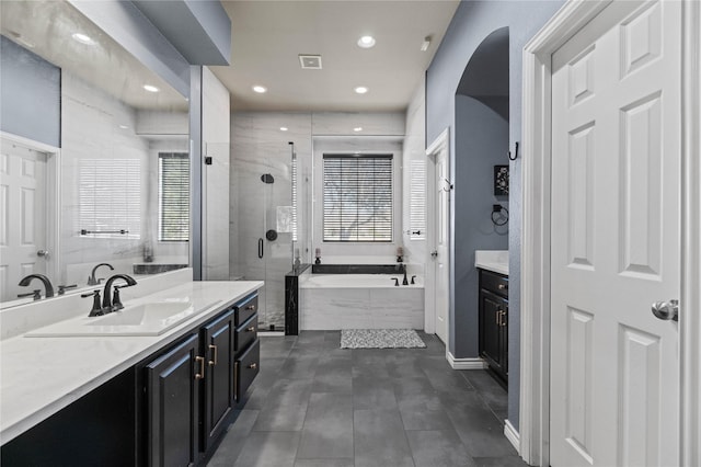 bathroom featuring recessed lighting, a stall shower, vanity, baseboards, and a bath