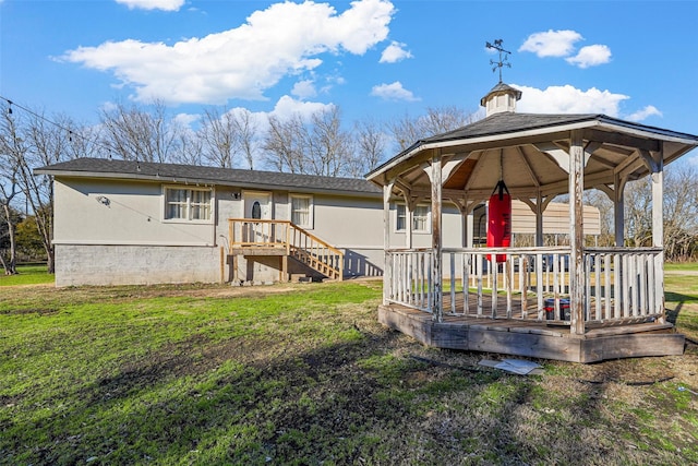 rear view of property featuring a yard and a gazebo