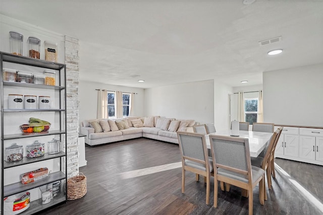 dining area with dark wood-type flooring, a wealth of natural light, and visible vents