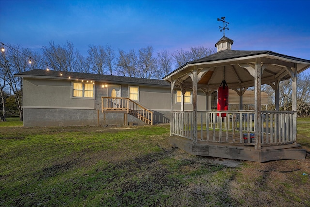 rear view of property with a gazebo and a yard